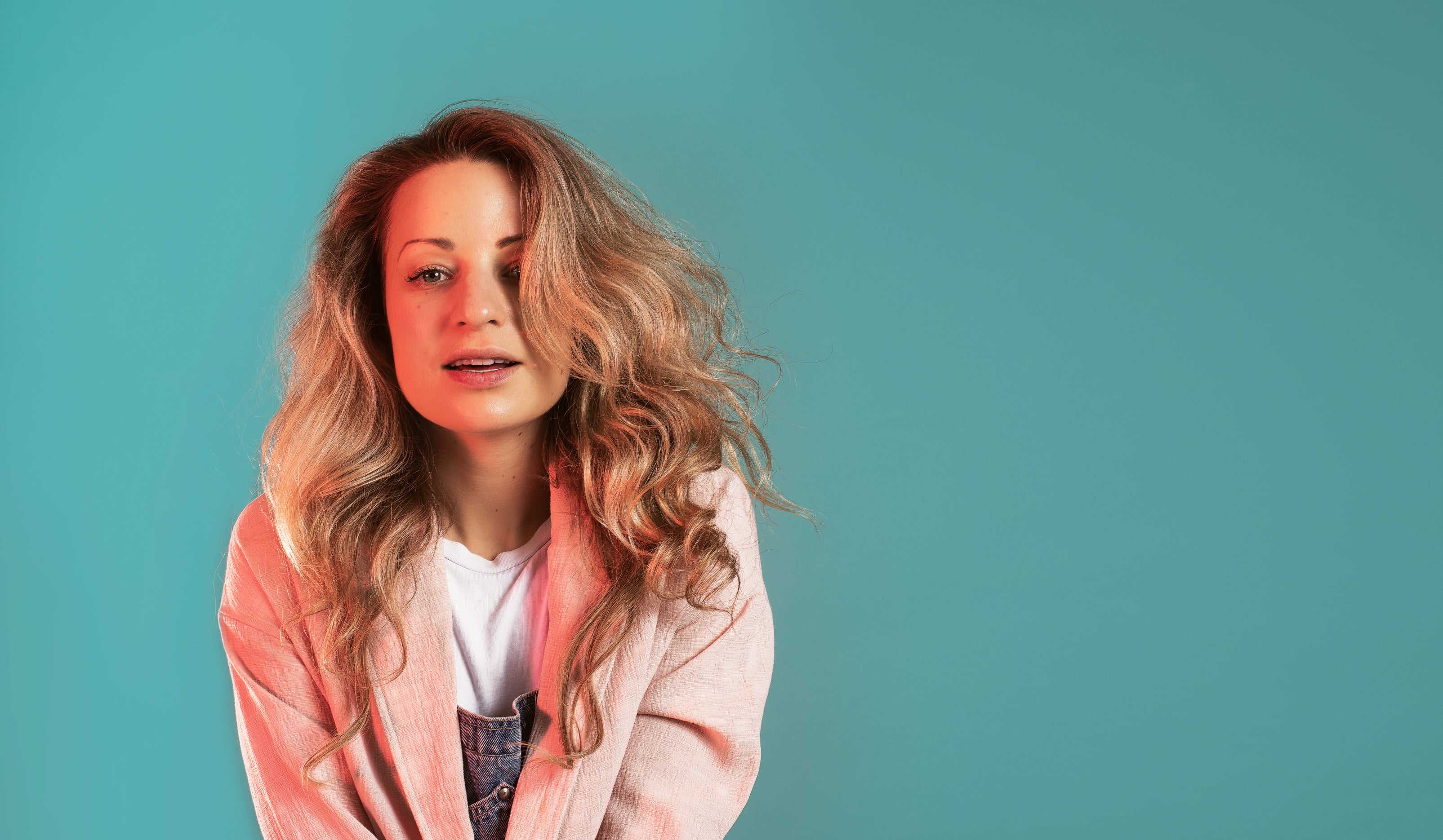 files/blonde-woman-caught-mid-smile-against-turquoise-wall.jpg